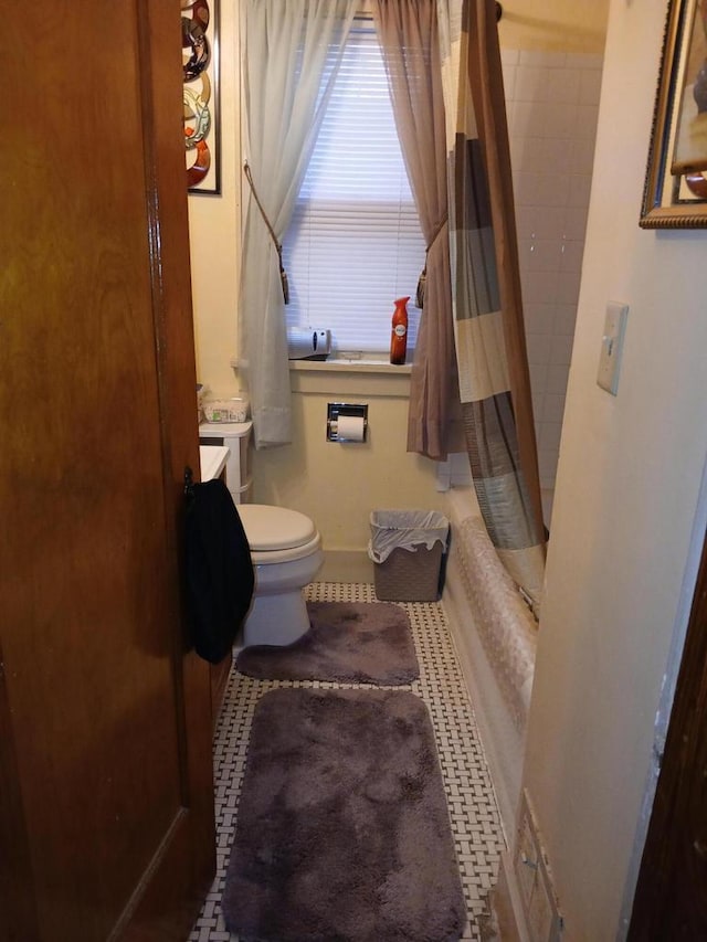 bathroom with vanity, shower / bath combination with curtain, toilet, and baseboards