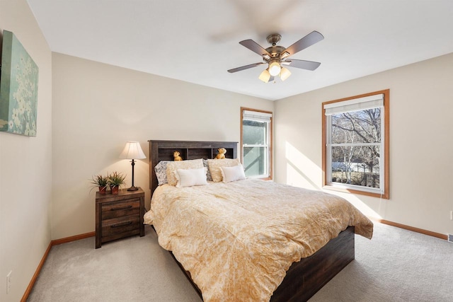 bedroom featuring light colored carpet, a ceiling fan, and baseboards