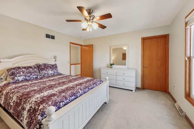 bedroom featuring a ceiling fan, baseboards, visible vents, and light carpet