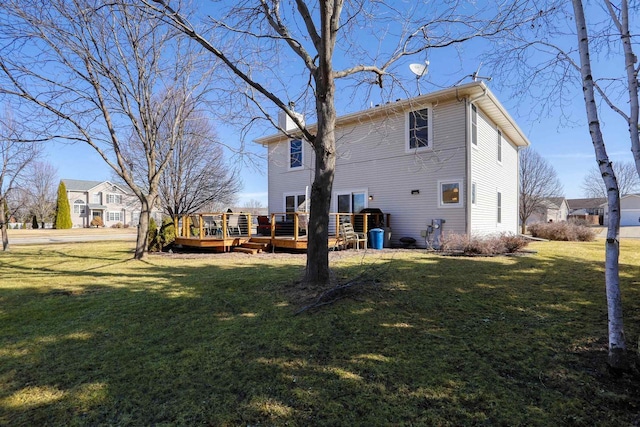 back of property with a wooden deck, a lawn, and a chimney