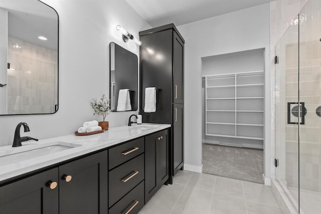 full bath with a spacious closet, tile patterned flooring, a sink, and a shower stall