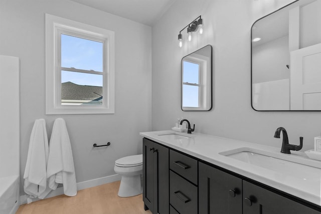 bathroom featuring plenty of natural light, a sink, and toilet