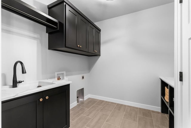 laundry area featuring cabinet space, baseboards, electric dryer hookup, washer hookup, and a sink