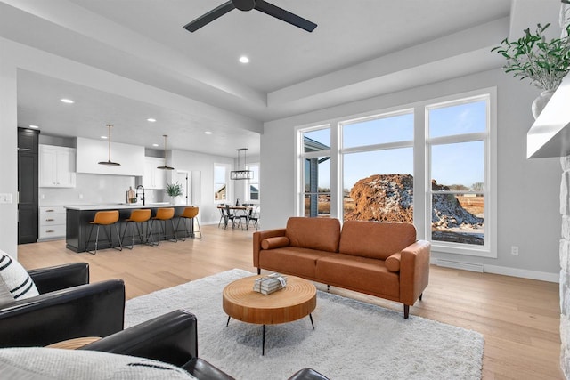 living area featuring light wood finished floors, baseboards, and recessed lighting