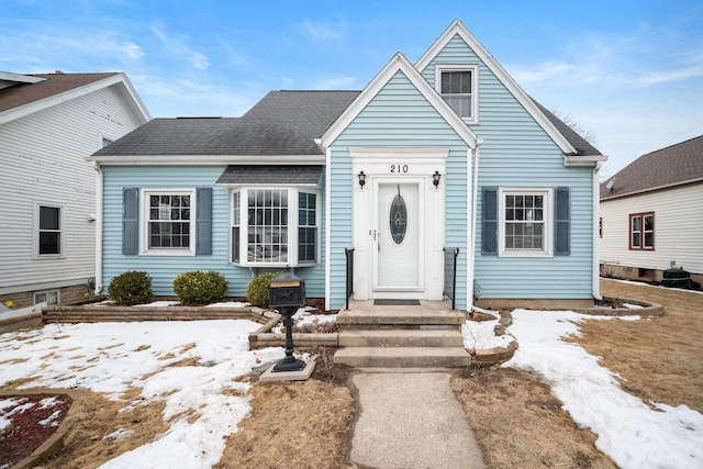 bungalow-style home with roof with shingles