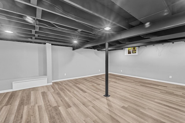 below grade area with baseboards and wood finished floors