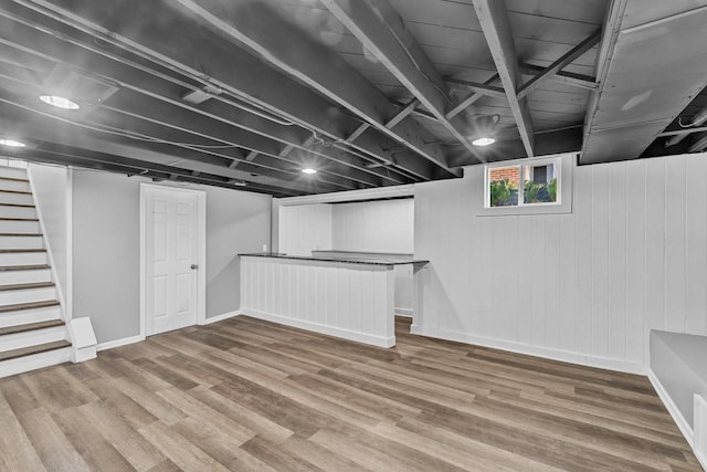 basement with stairway, wood finished floors, and baseboards