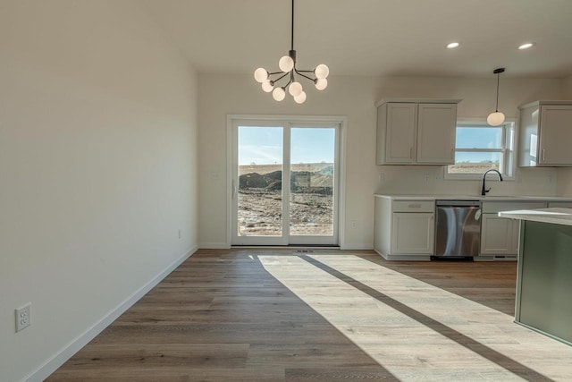 kitchen featuring dishwasher, baseboards, and a healthy amount of sunlight