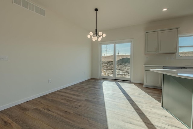 unfurnished dining area with recessed lighting, visible vents, baseboards, and wood finished floors