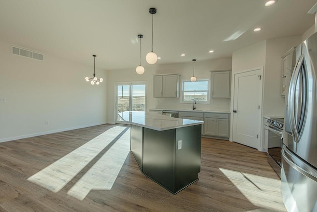 kitchen featuring visible vents, wood finished floors, stainless steel appliances, a sink, and recessed lighting