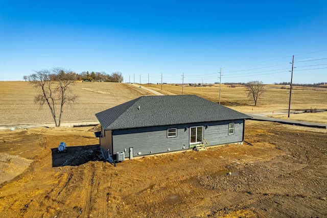 view of front of home featuring central AC and a rural view