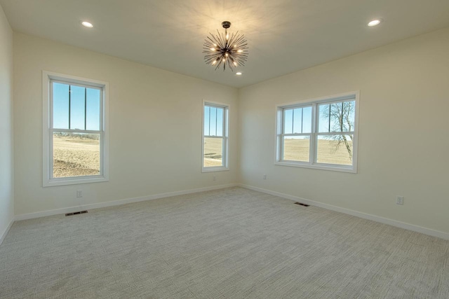 empty room with a chandelier, recessed lighting, and plenty of natural light