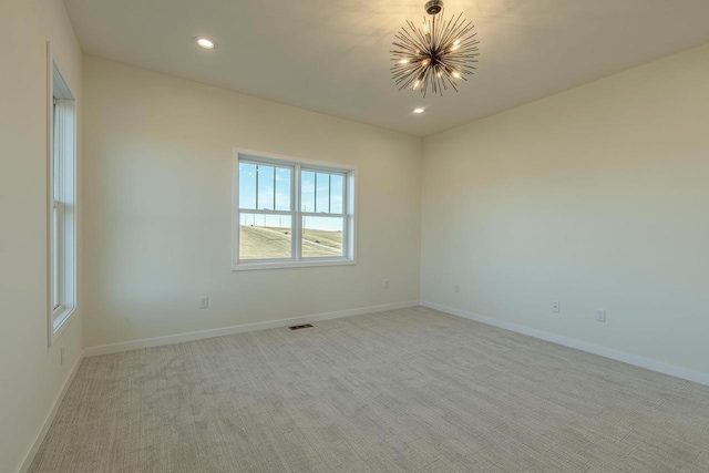 unfurnished room with recessed lighting, light colored carpet, visible vents, an inviting chandelier, and baseboards