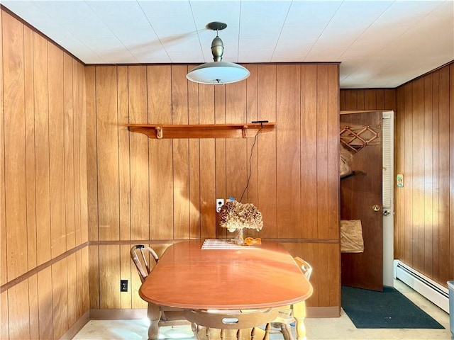 dining space featuring wooden walls and baseboard heating