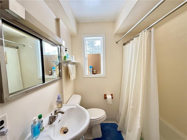 bathroom with toilet, baseboards, a sink, and a shower with shower curtain