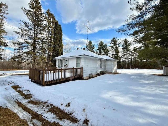 snow covered rear of property featuring a wooden deck