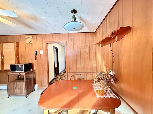 dining area with wooden walls and baseboard heating