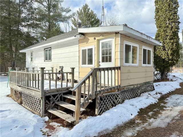 snow covered property with a wooden deck