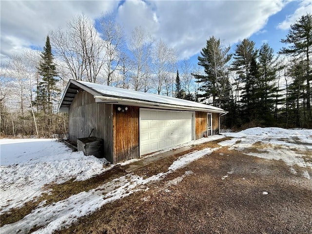 snow covered garage featuring a garage