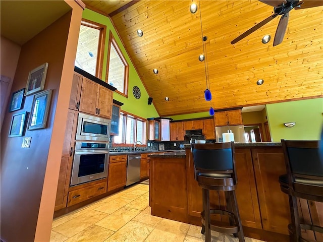 kitchen featuring hanging light fixtures, a breakfast bar, brown cabinets, and stainless steel appliances