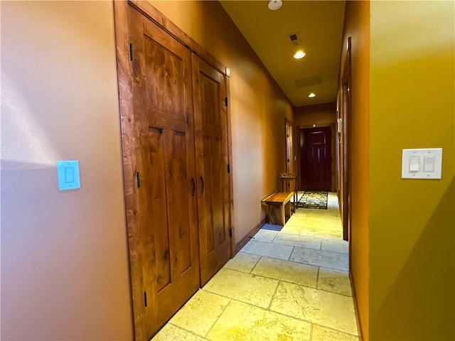 corridor with visible vents, stone tile flooring, and recessed lighting