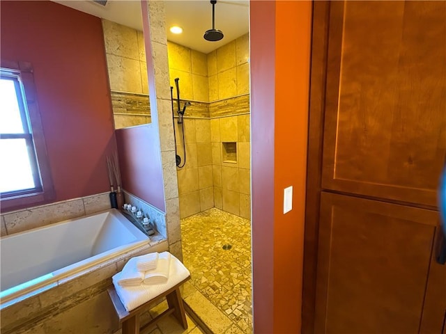 full bath with a garden tub, visible vents, a tile shower, and a wealth of natural light