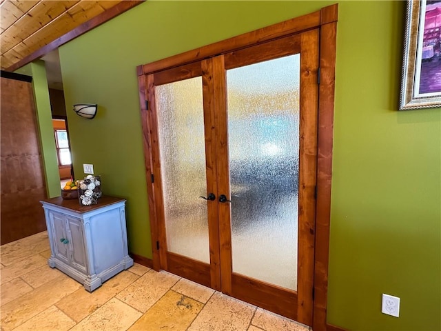 entryway with baseboards, stone tile flooring, and french doors