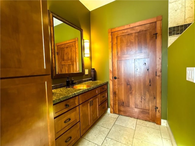 bathroom with vanity and stone tile floors