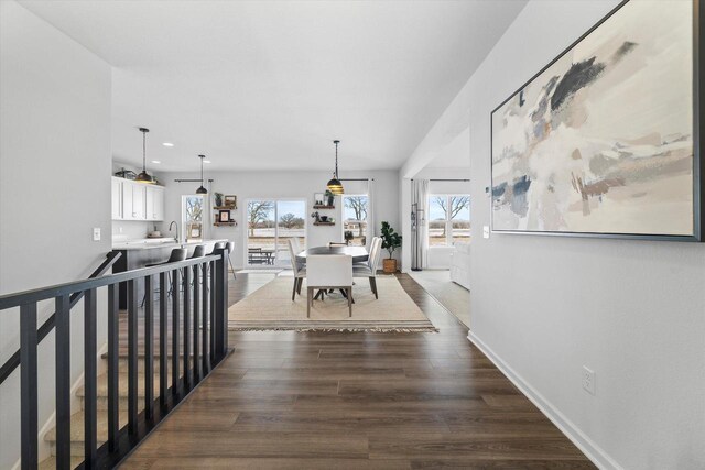hallway featuring dark wood-style floors, a sink, recessed lighting, and baseboards