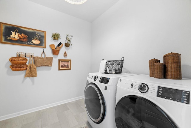 clothes washing area featuring separate washer and dryer and baseboards