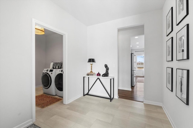 washroom featuring washing machine and dryer and baseboards