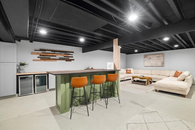 indoor dry bar with wine cooler and concrete flooring
