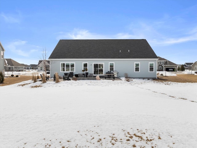 view of snow covered back of property