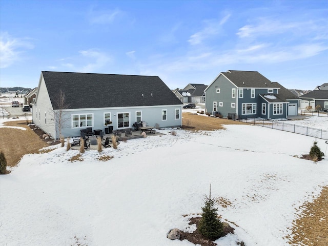 snow covered rear of property with fence and a residential view