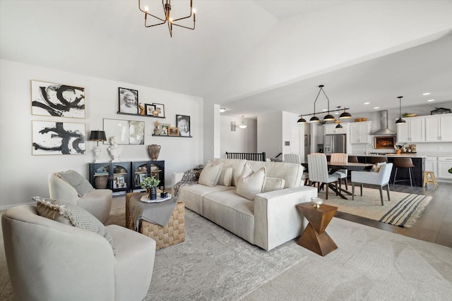 living room with a chandelier, light wood-type flooring, lofted ceiling, and recessed lighting