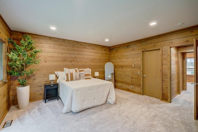 bedroom with wood walls, carpet floors, and visible vents
