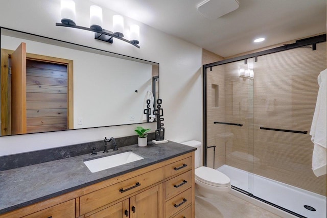 bathroom with recessed lighting, vanity, toilet, and a stall shower