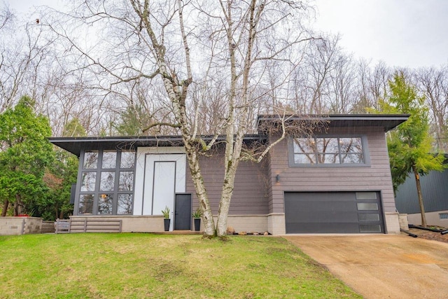 view of front of property featuring a front lawn, driveway, and a garage