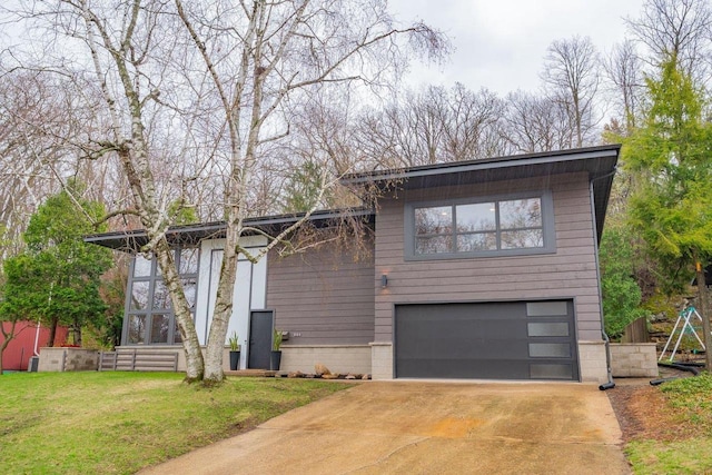 view of front of property featuring concrete driveway, a front yard, and a garage