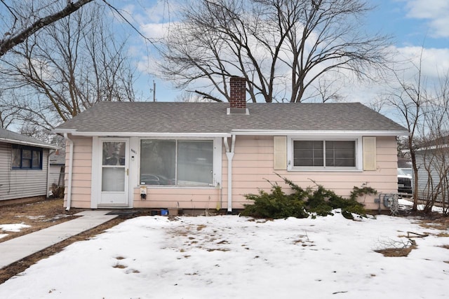 bungalow-style house featuring a shingled roof and a chimney