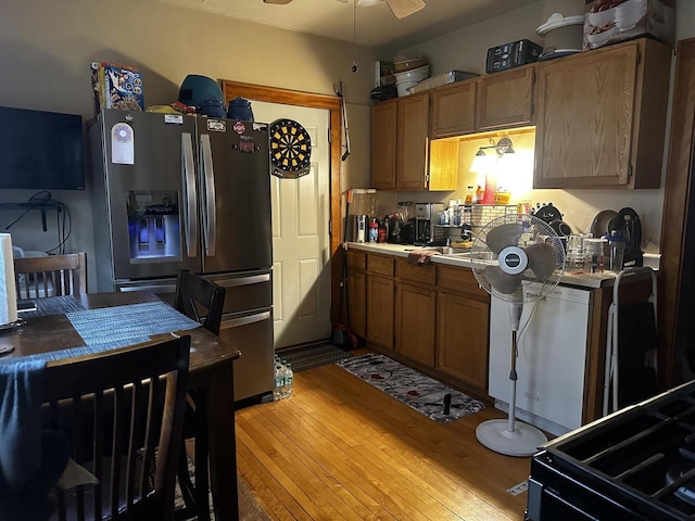 kitchen featuring a ceiling fan, light wood-style flooring, brown cabinets, light countertops, and stainless steel refrigerator with ice dispenser