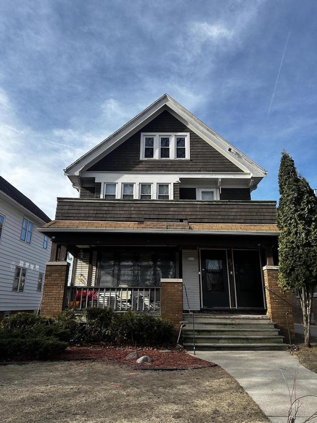 view of front facade featuring covered porch and brick siding