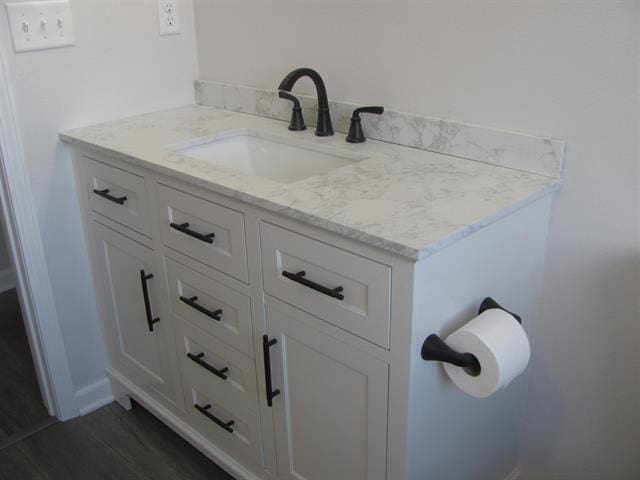 bathroom featuring vanity, baseboards, and wood finished floors