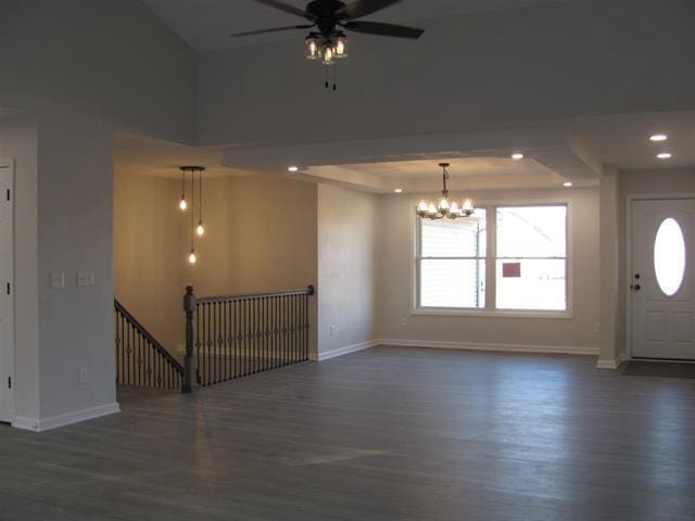 unfurnished room featuring a tray ceiling, baseboards, dark wood-style flooring, and recessed lighting