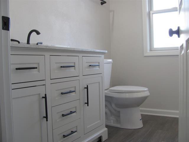 bathroom featuring toilet, baseboards, and wood finished floors