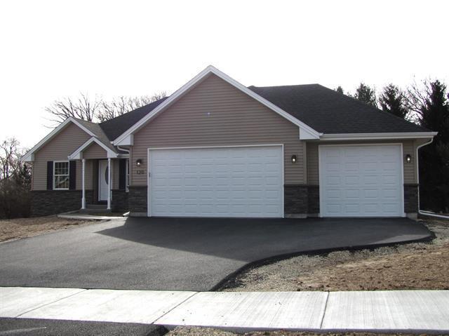 ranch-style home featuring a garage and aphalt driveway