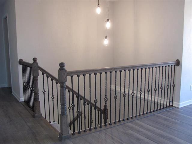 staircase featuring wood finished floors and baseboards