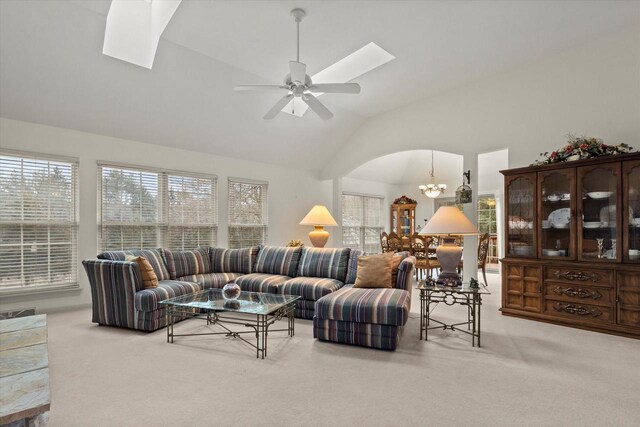 S32W32807 Bethania Ln, Dousman, WI 53118 - carpeted living area with lofted ceiling with skylight, arched walkways, and ceiling fan with notable chandelier