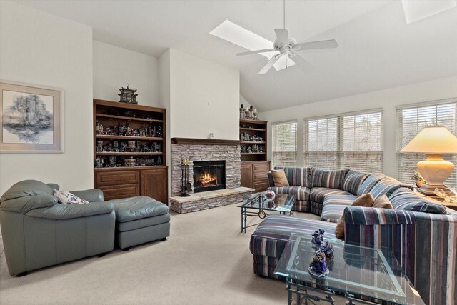 S32W32807 Bethania Ln, Dousman, WI 53118 - carpeted living room with vaulted ceiling with skylight, a fireplace, ceiling fan, and a wealth of natural light