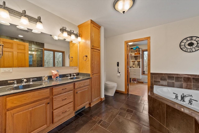 full bathroom featuring a bath, a shower stall, double vanity, and a sink